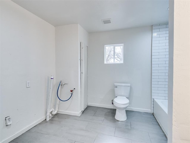 bathroom with toilet, baseboards, visible vents, and a tub