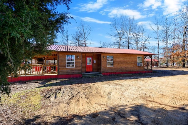 rustic home featuring metal roof and cooling unit