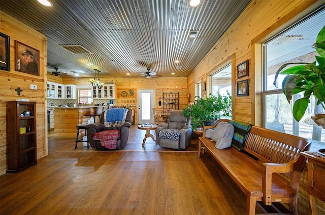 living room featuring ceiling fan, recessed lighting, wood walls, wood finished floors, and visible vents