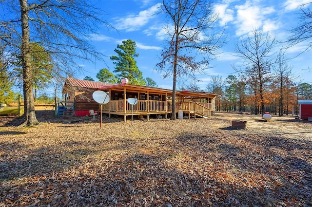 back of house with metal roof and a wooden deck