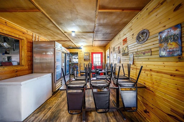 dining room featuring wooden walls and wood finished floors