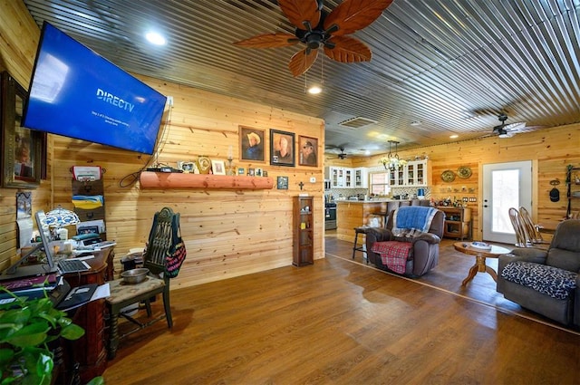 interior space featuring wooden walls, visible vents, wood finished floors, and ceiling fan