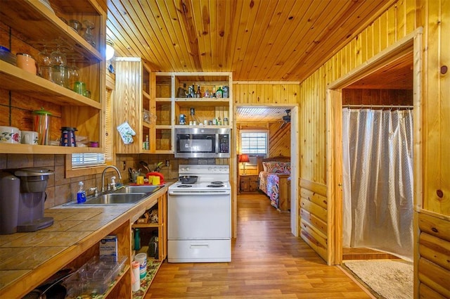 kitchen featuring stainless steel microwave, open shelves, electric stove, tile countertops, and a sink