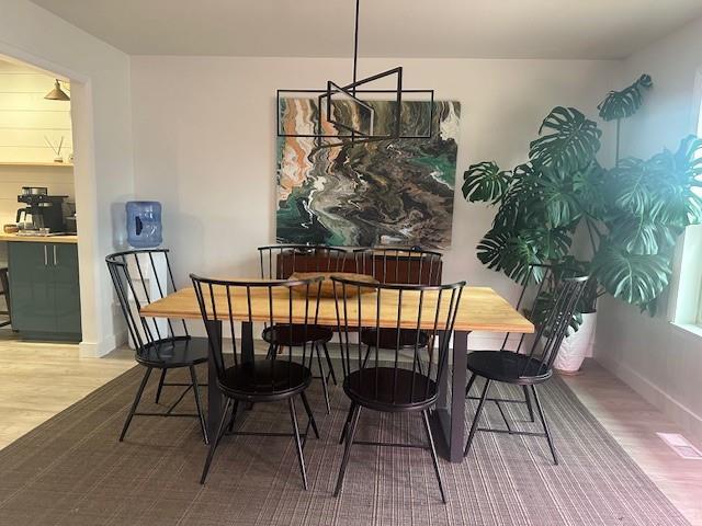 dining space with baseboards and wood finished floors