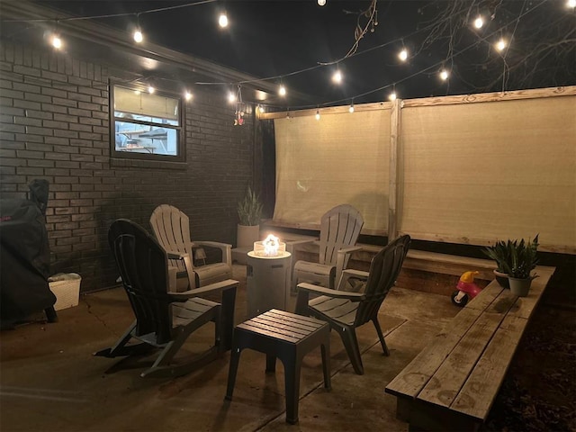 patio at night featuring an outdoor fire pit and area for grilling