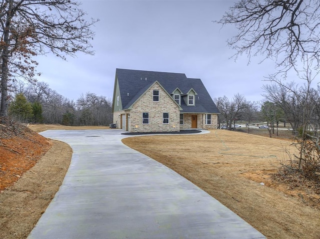 view of front of home featuring driveway, stone siding, and a garage