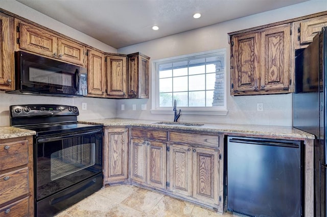 kitchen with a sink, black appliances, brown cabinetry, and recessed lighting