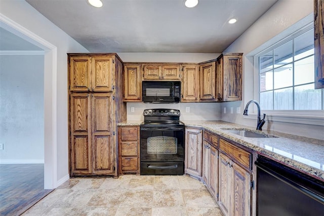 kitchen featuring baseboards, light stone countertops, recessed lighting, black appliances, and a sink