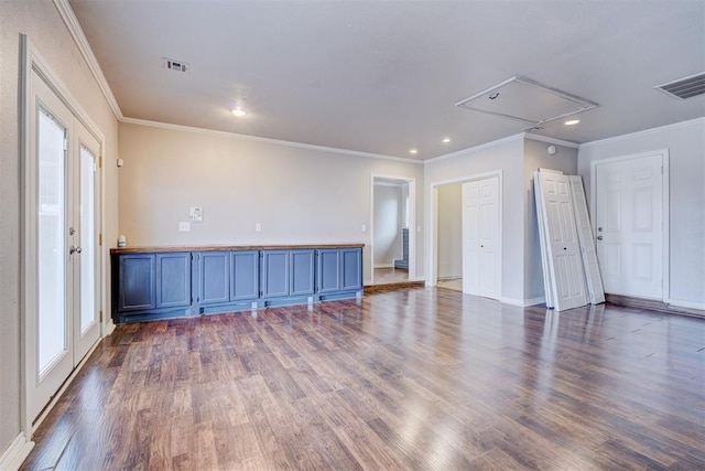 spare room featuring attic access, visible vents, and dark wood-type flooring