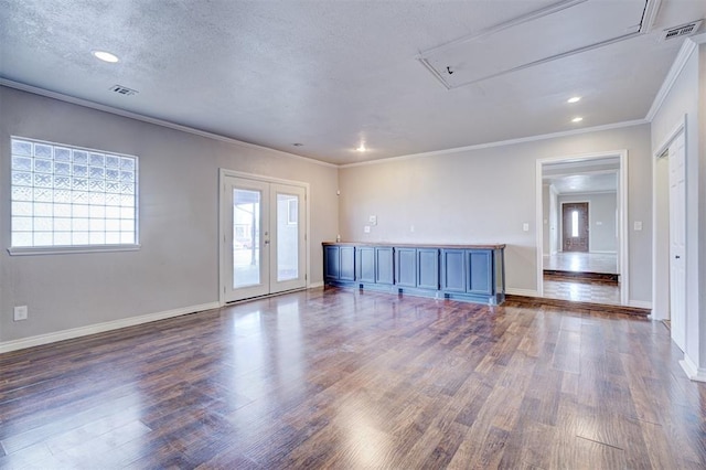 unfurnished living room with visible vents, french doors, crown molding, and wood finished floors