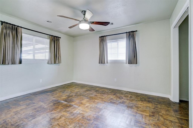 spare room featuring visible vents, baseboards, and ceiling fan