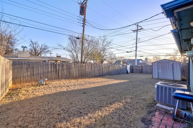 view of yard featuring a fenced backyard, an outdoor structure, a storage shed, and central AC