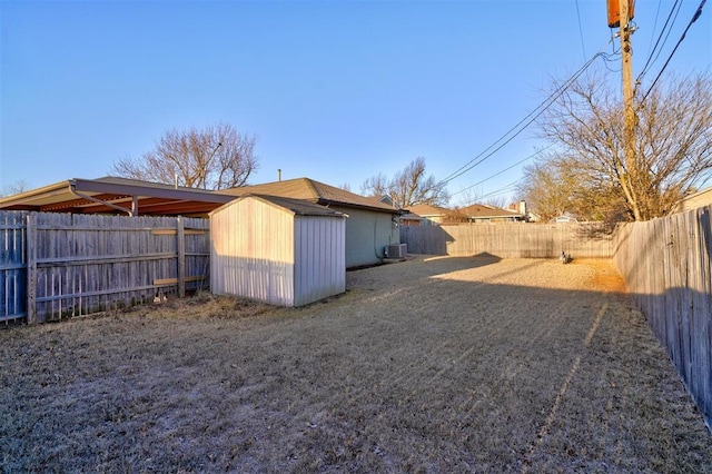 view of yard featuring an outbuilding, a fenced backyard, and a shed