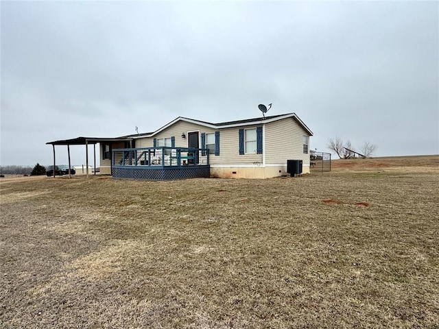 exterior space with cooling unit, a yard, and a wooden deck