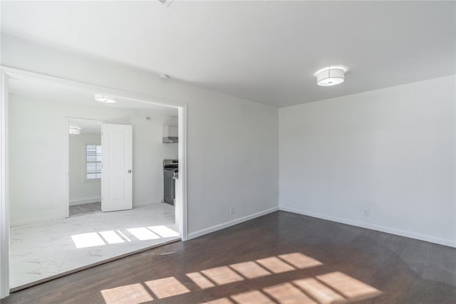 unfurnished room with baseboards and wood finished floors