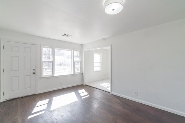 foyer entrance with baseboards, visible vents, and wood finished floors