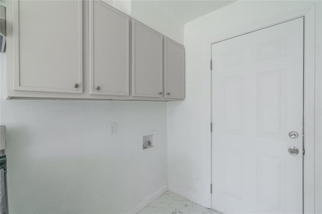 clothes washing area featuring marble finish floor, baseboards, washer hookup, and cabinet space