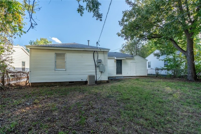 rear view of house with a yard, fence, and central air condition unit