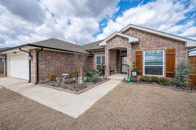 ranch-style house with driveway, brick siding, roof with shingles, and an attached garage