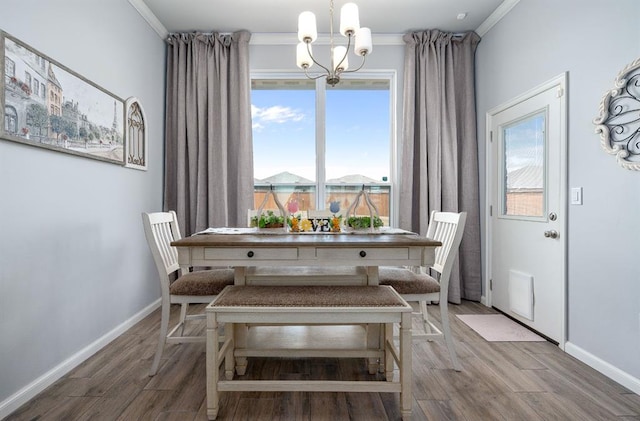 dining room with plenty of natural light, an inviting chandelier, baseboards, and wood finished floors