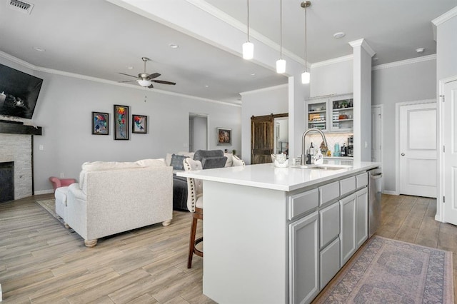 kitchen with open floor plan, visible vents, a barn door, and a sink