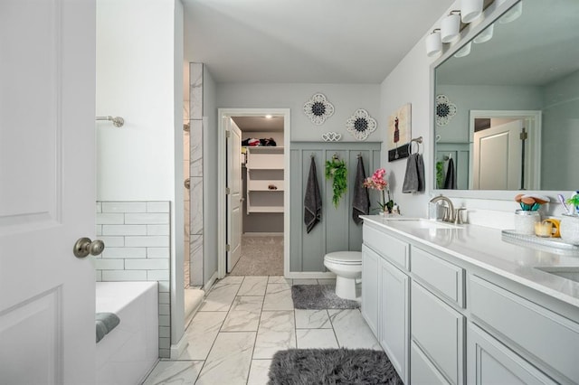 full bath featuring vanity, a stall shower, a walk in closet, a bath, and marble finish floor