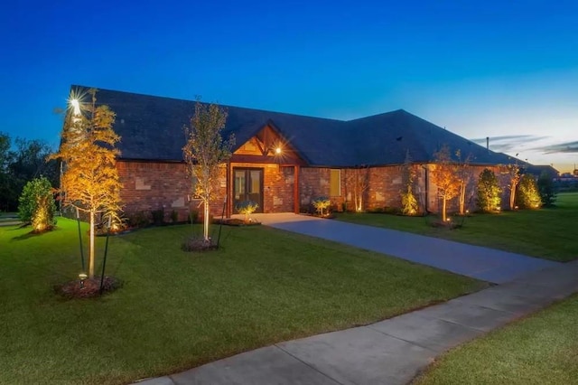 single story home featuring brick siding and a lawn