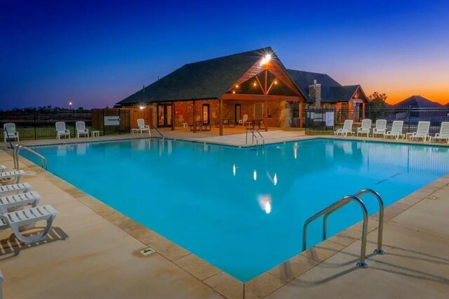 community pool with a patio and fence