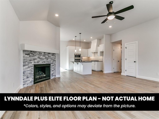 unfurnished living room featuring a tile fireplace, ceiling fan, light wood-type flooring, and baseboards