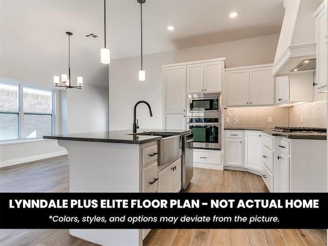 kitchen featuring stainless steel appliances, dark countertops, backsplash, visible vents, and a notable chandelier