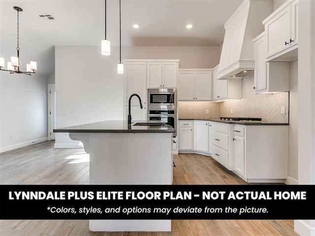 kitchen featuring appliances with stainless steel finishes, an inviting chandelier, dark countertops, and custom range hood