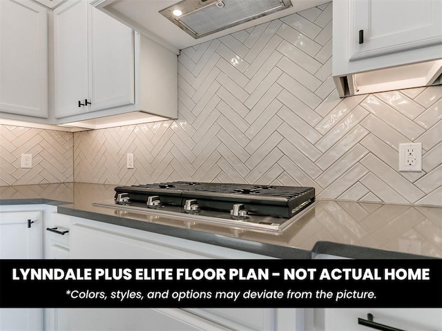 kitchen with dark countertops, exhaust hood, white cabinets, and backsplash