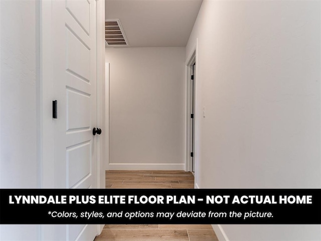hallway featuring baseboards, visible vents, and light wood-style floors