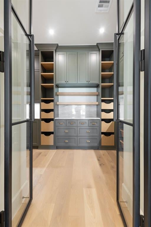 walk in closet with light wood finished floors and visible vents