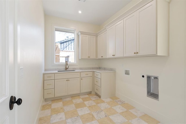 laundry room with hookup for an electric dryer, washer hookup, a sink, baseboards, and cabinet space