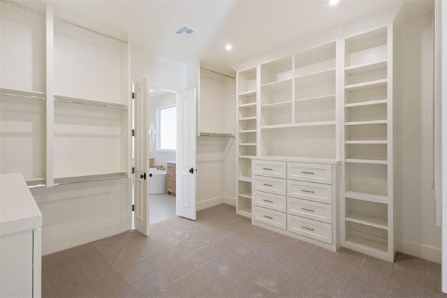 spacious closet featuring light colored carpet and visible vents