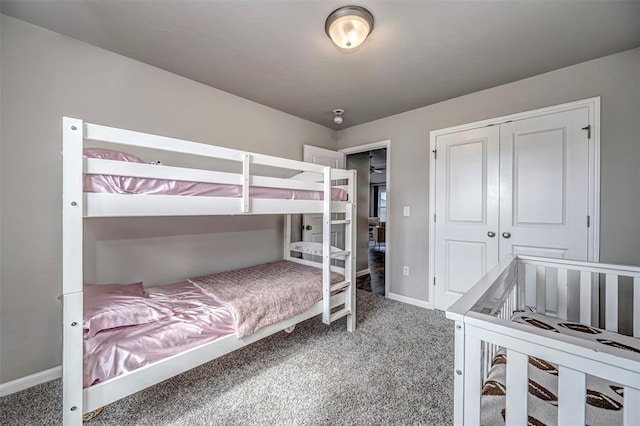 carpeted bedroom featuring baseboards and a closet