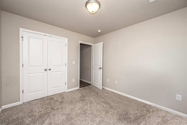 unfurnished bedroom featuring a closet, carpet flooring, and baseboards