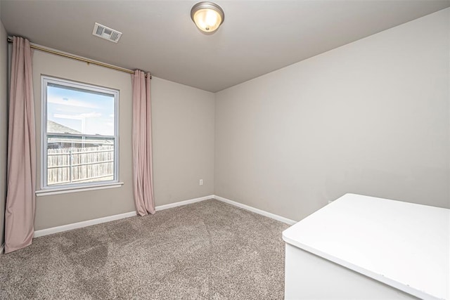 carpeted empty room featuring baseboards and visible vents