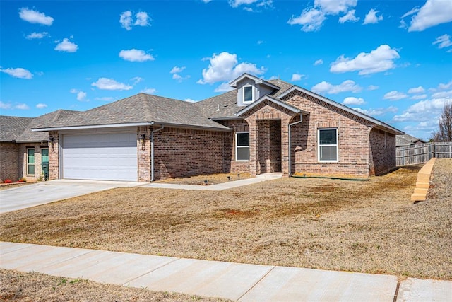 view of front of house featuring driveway, an attached garage, fence, and brick siding