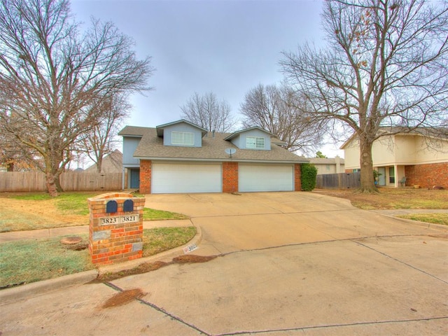 view of front facade featuring a garage, concrete driveway, brick siding, and fence