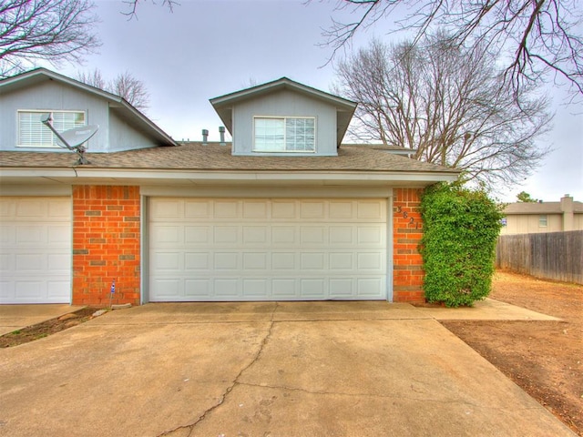 garage with driveway and fence