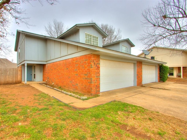 view of front of home with a garage, driveway, fence, and brick siding