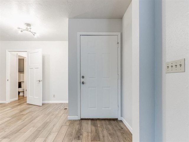 interior space with baseboards and light wood-style floors