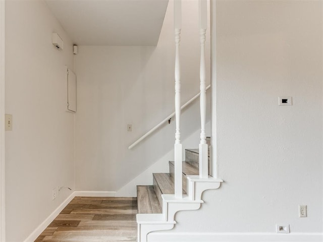 staircase with wood finished floors and baseboards