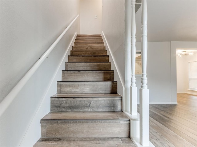 stairs featuring wood finished floors and baseboards