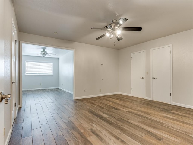 spare room featuring a ceiling fan, baseboards, and wood finished floors