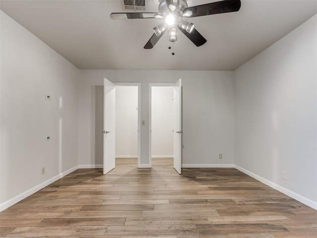 unfurnished bedroom with visible vents, wood finished floors, a ceiling fan, and baseboards