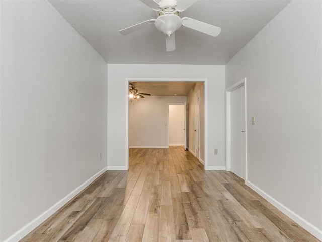 unfurnished room with a ceiling fan, baseboards, and light wood finished floors