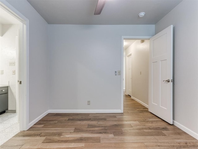 empty room featuring ceiling fan, wood finished floors, and baseboards